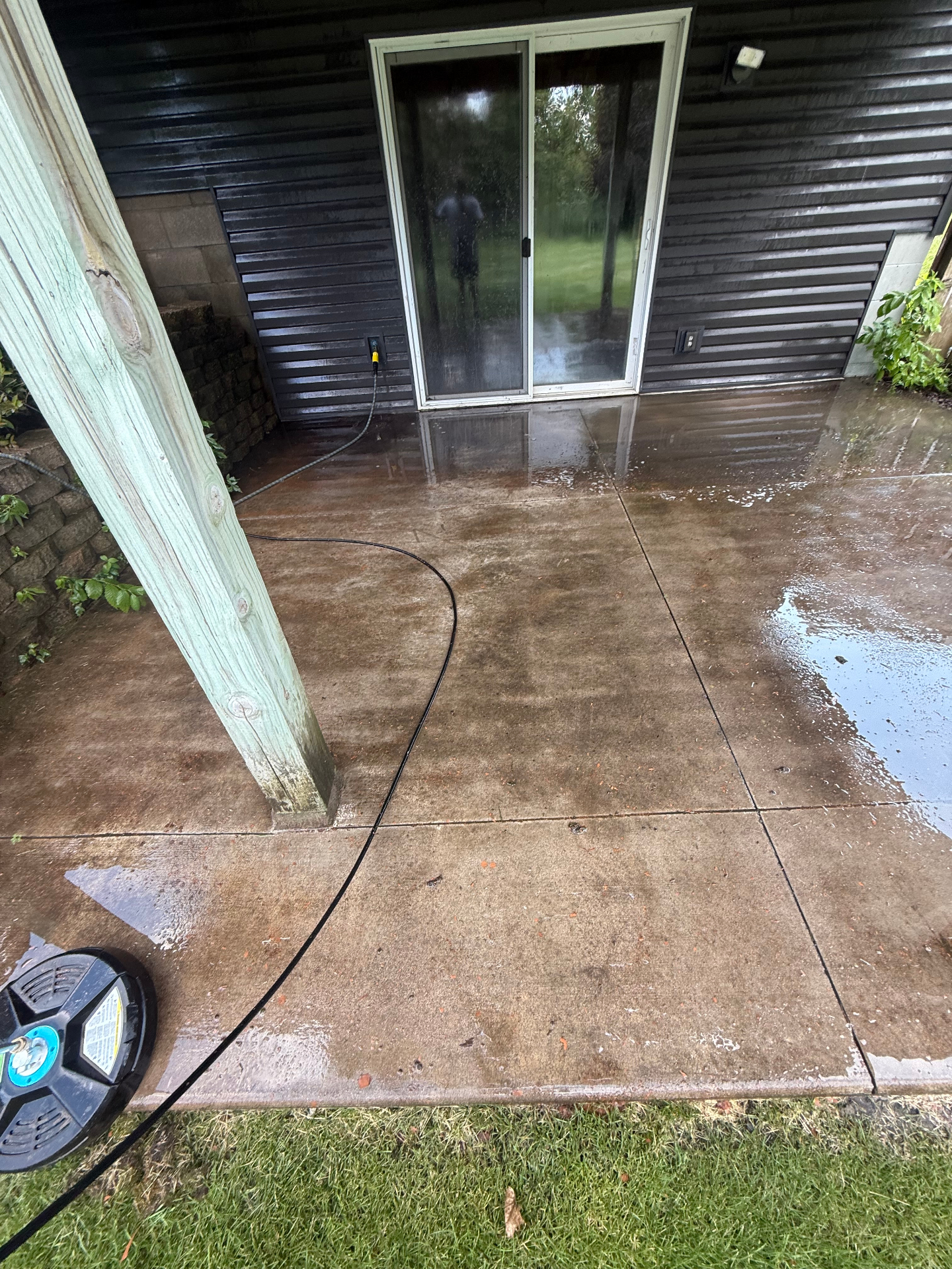 Concrete patio mid-clean showing dirt lifting off