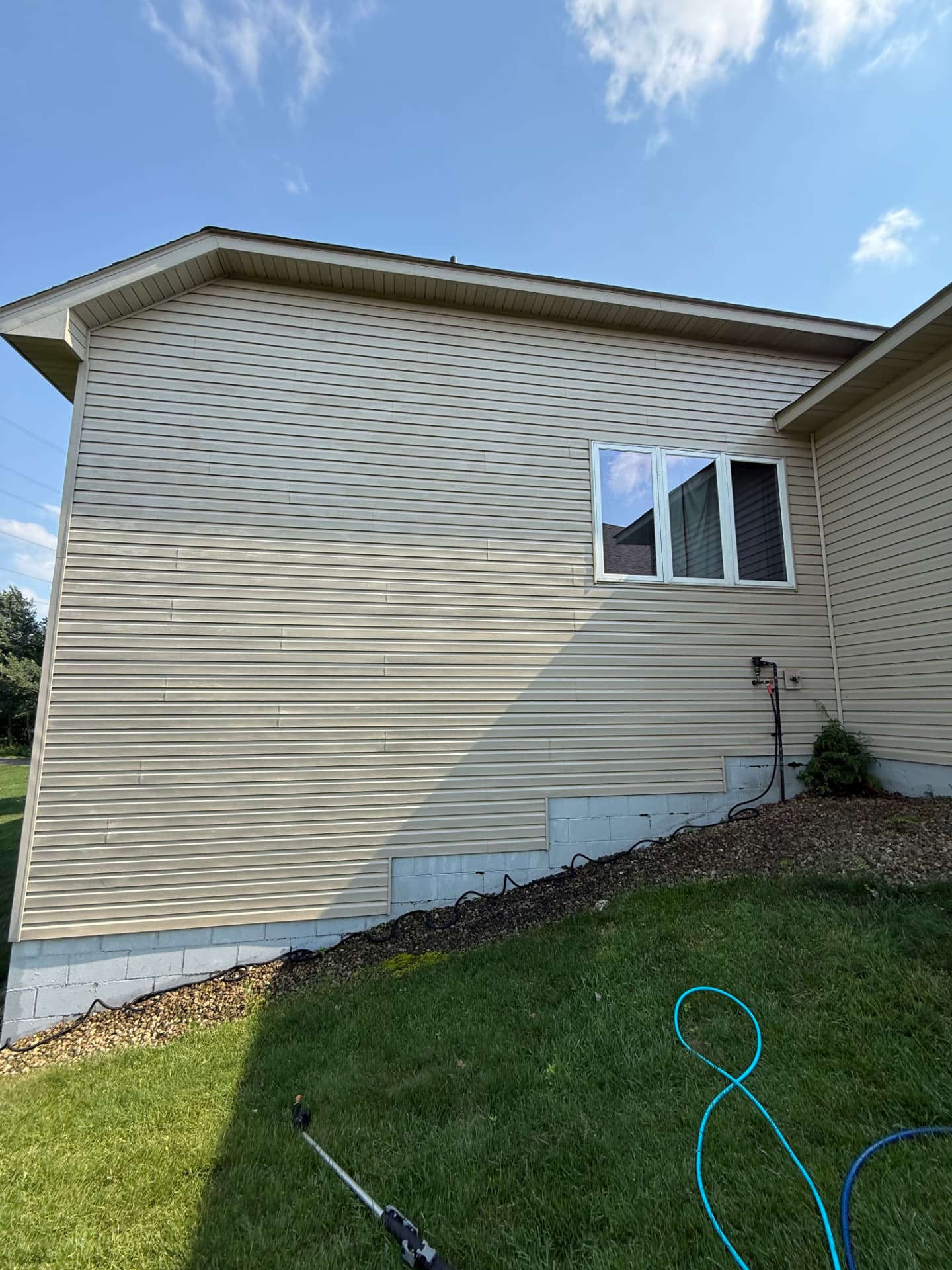 Clean tan vinyl siding after a soft wash in Blaine, Minnesota