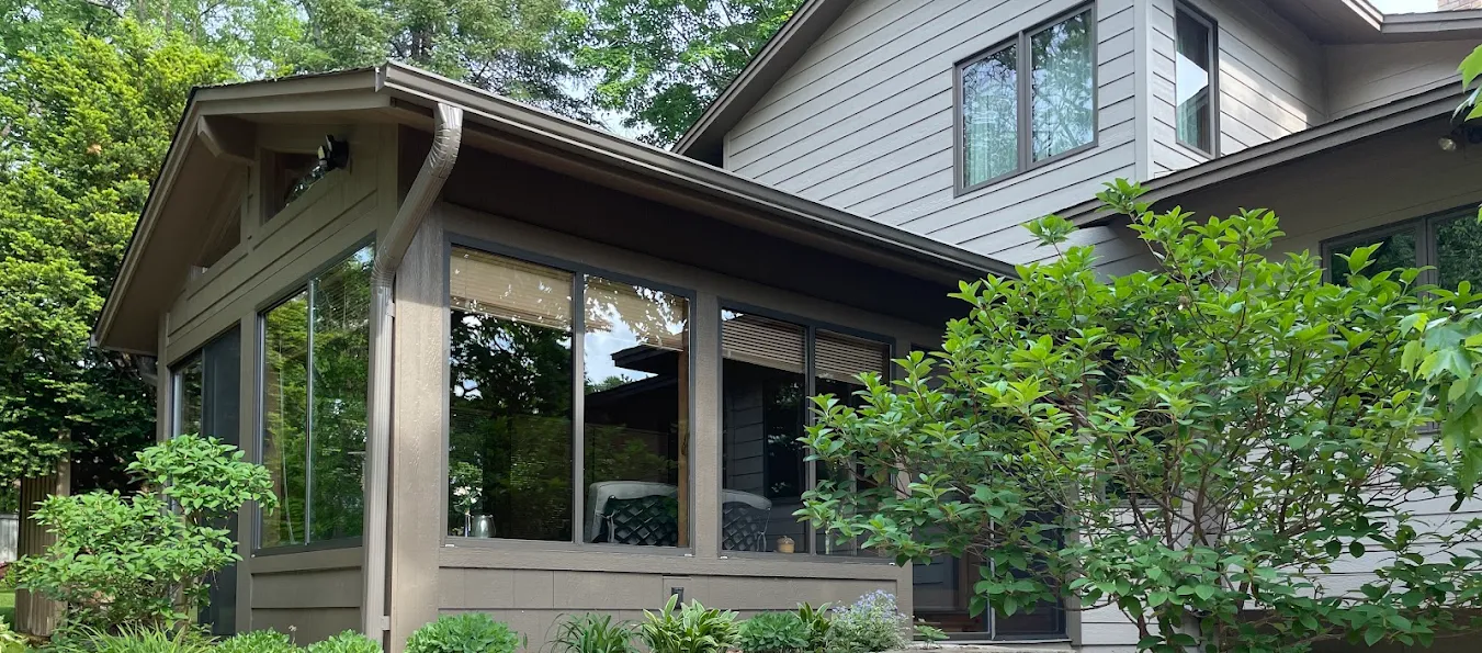 Sunroom with spotless windows surrounded by greenery